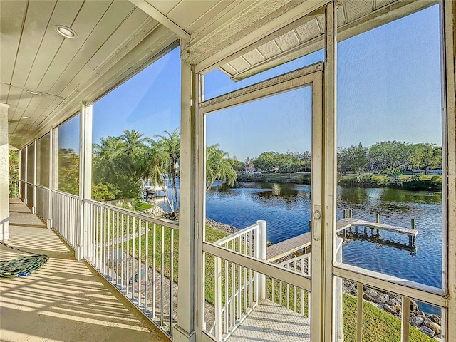 sunroom / solarium featuring a water view and wood ceiling