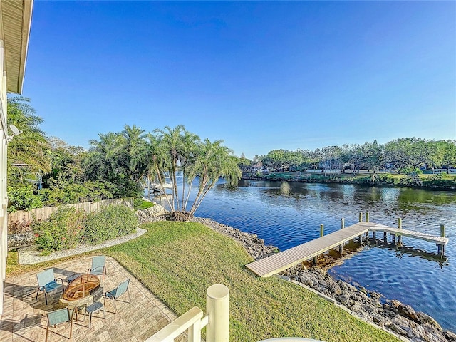 dock area with a water view, a lawn, a patio area, and a fire pit