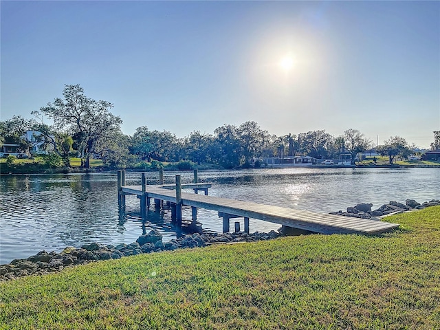 dock area featuring a lawn and a water view