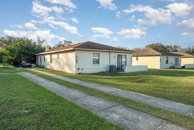 ranch-style home featuring a front lawn and central air condition unit