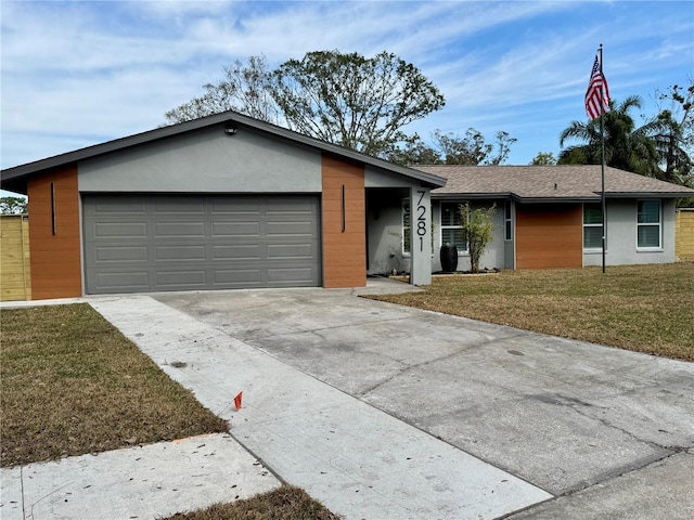 single story home featuring a garage and a front yard