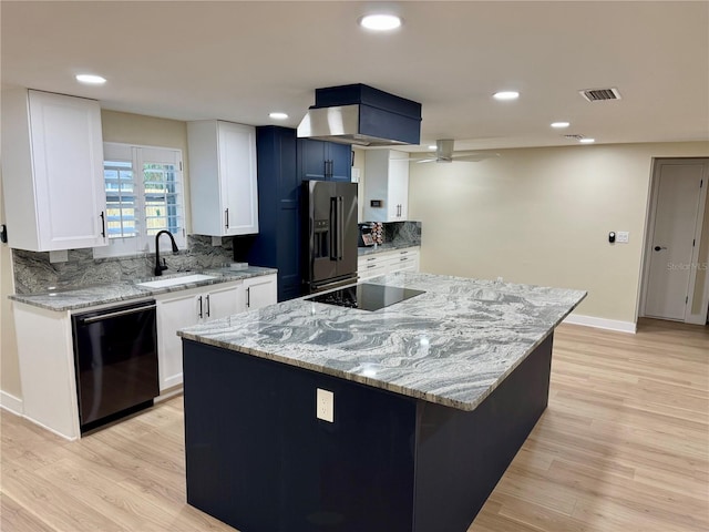 kitchen with white cabinetry, a center island, sink, and black appliances