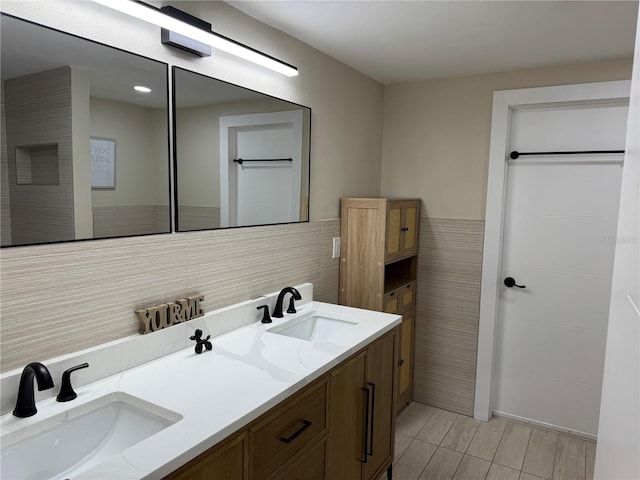 bathroom featuring vanity and tile walls