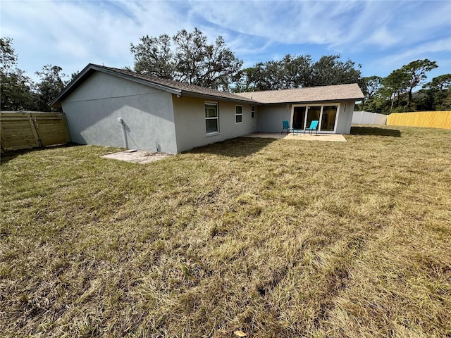 back of house with a lawn and a patio area