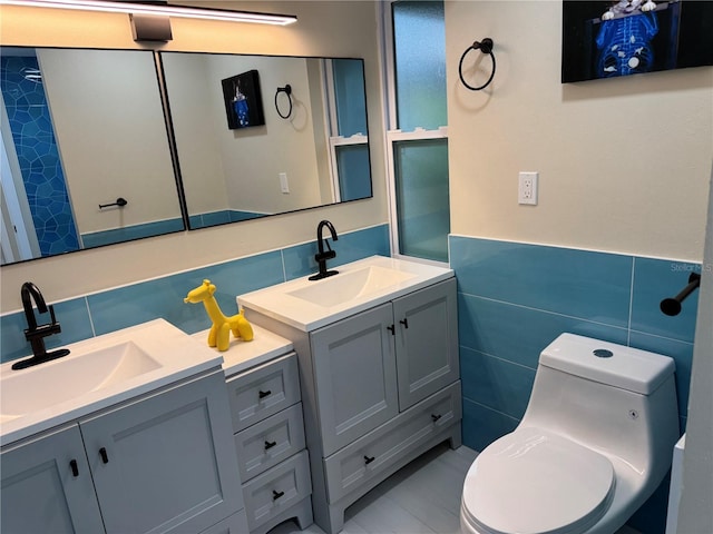 bathroom with vanity, tile walls, and toilet