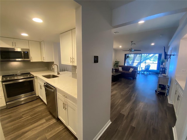 kitchen featuring appliances with stainless steel finishes, dark hardwood / wood-style floors, white cabinetry, sink, and decorative backsplash