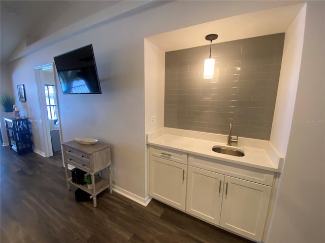 interior space with hanging light fixtures, sink, white cabinets, and dark hardwood / wood-style flooring