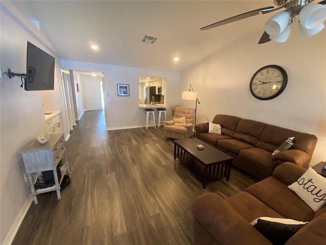 living room featuring ceiling fan and dark hardwood / wood-style flooring