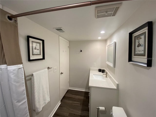 bathroom with wood-type flooring, toilet, and vanity