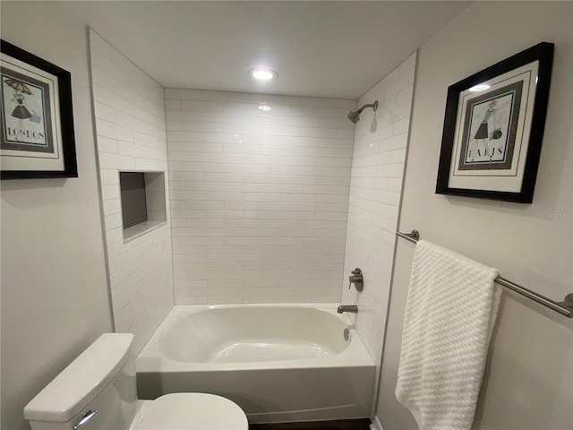 bathroom featuring tiled shower / bath combo and toilet