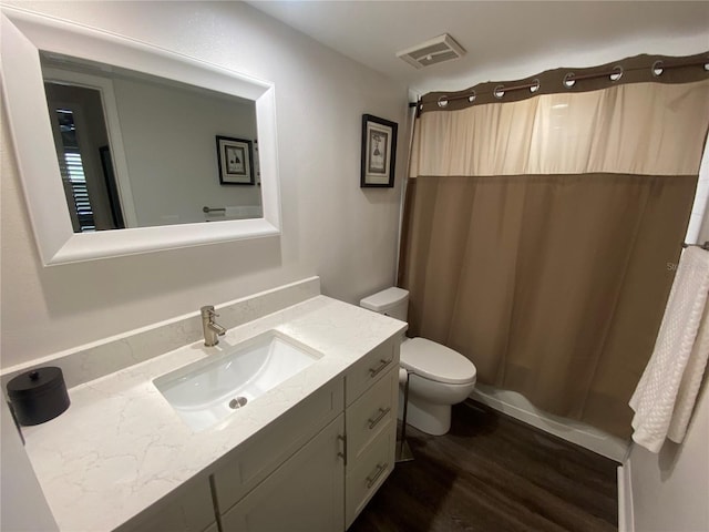 bathroom featuring hardwood / wood-style flooring, vanity, toilet, and walk in shower