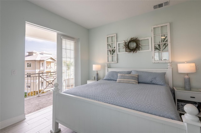 bedroom with access to exterior and light wood-type flooring