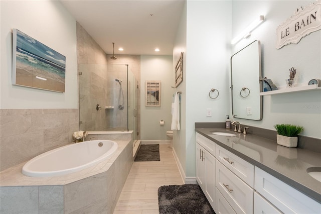 full bathroom featuring vanity, separate shower and tub, and toilet