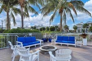 view of patio featuring a wooden deck and an outdoor living space with a fire pit