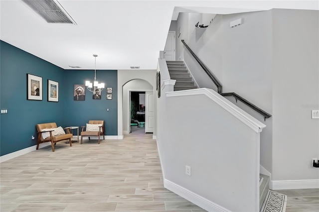 stairs featuring a chandelier