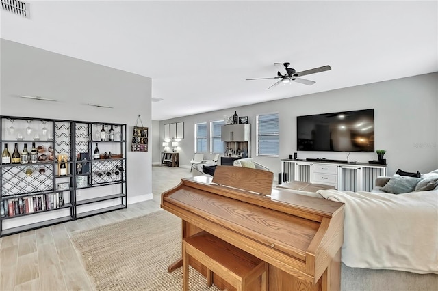 living room with light hardwood / wood-style floors and ceiling fan