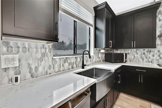 kitchen with sink, decorative backsplash, light hardwood / wood-style flooring, and stainless steel dishwasher