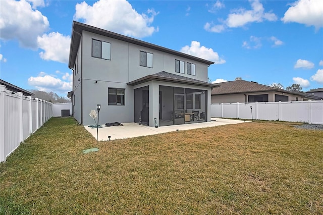 rear view of house featuring a patio, a sunroom, a yard, and central AC