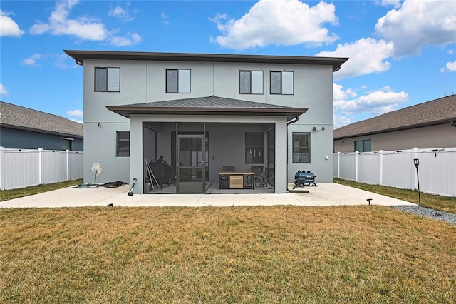 back of property featuring a yard, a patio area, and a sunroom