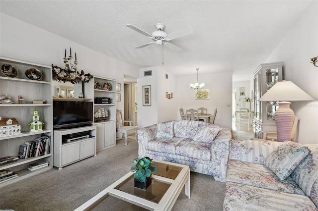 carpeted living room with ceiling fan with notable chandelier and a textured ceiling