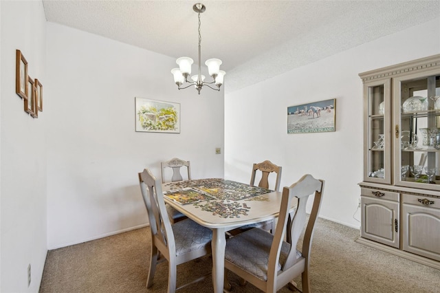 dining space with carpet floors, a notable chandelier, and a textured ceiling