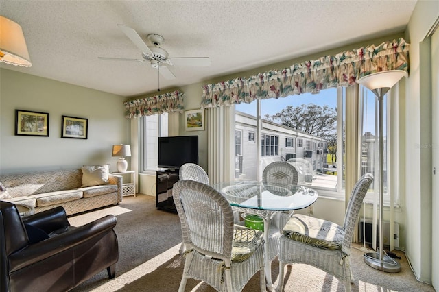 dining room featuring a textured ceiling, carpet floors, and ceiling fan