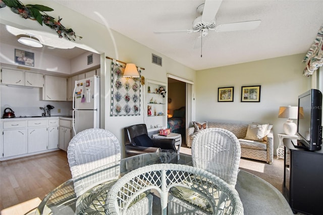 dining space featuring light hardwood / wood-style floors and ceiling fan