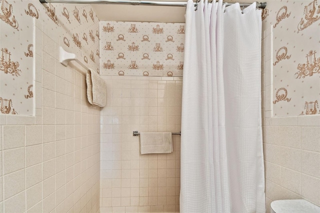 bathroom featuring tile walls and walk in shower