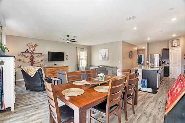 dining area with ceiling fan and light wood-type flooring