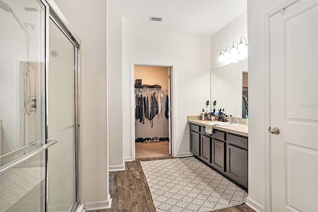 bathroom with vanity, a shower with door, and hardwood / wood-style floors