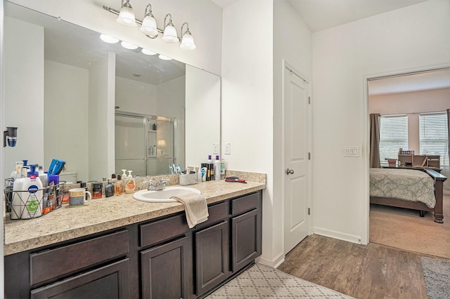 bathroom featuring vanity, wood-type flooring, and a shower with door