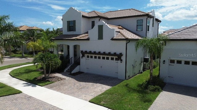 mediterranean / spanish-style home featuring a garage and a front yard