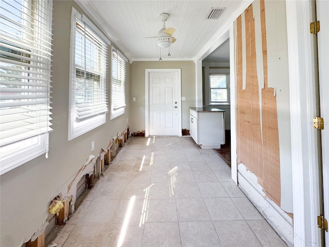 interior space with light tile patterned flooring, ornamental molding, and ceiling fan