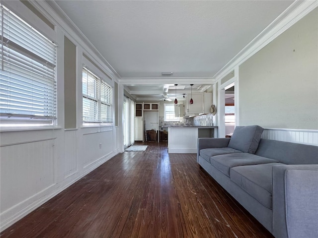 unfurnished living room with dark hardwood / wood-style flooring, ornamental molding, and ceiling fan