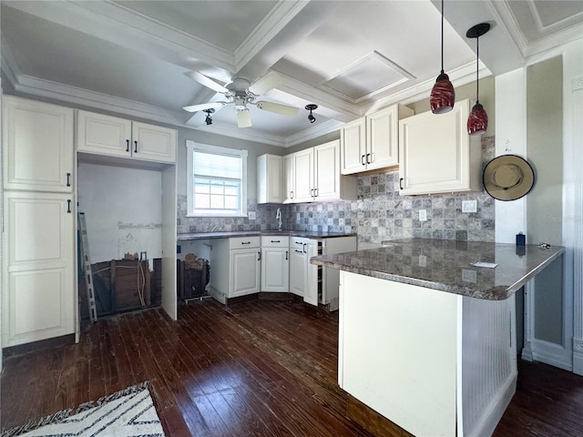 kitchen with white cabinetry, crown molding, dark hardwood / wood-style flooring, and kitchen peninsula