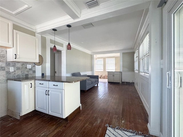 kitchen featuring dark hardwood / wood-style floors, decorative light fixtures, white cabinets, kitchen peninsula, and crown molding