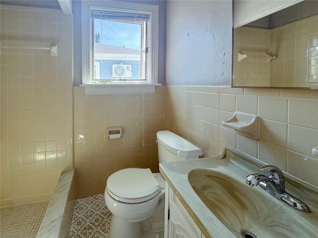 bathroom with tile patterned floors, toilet, a shower, tile walls, and vanity