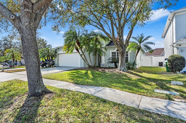 view of front of property with cooling unit, a garage, and a front lawn