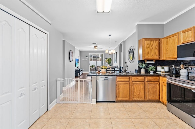 kitchen with sink, decorative light fixtures, light tile patterned floors, appliances with stainless steel finishes, and kitchen peninsula