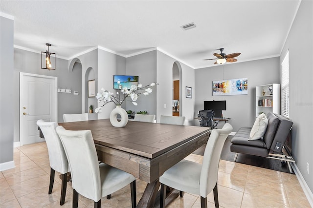 tiled dining area featuring crown molding, ceiling fan, and a textured ceiling