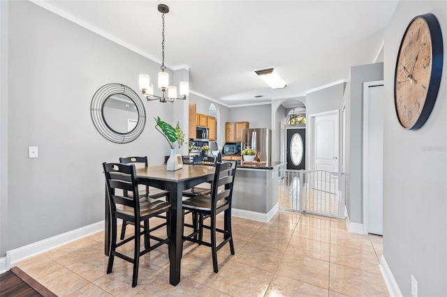 dining area with ornamental molding, a chandelier, and light tile patterned floors