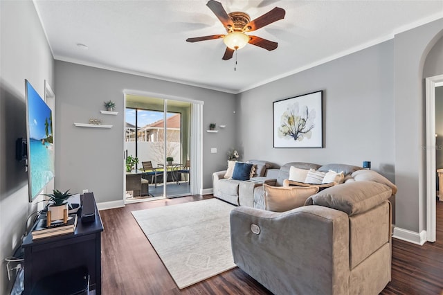 living room featuring ceiling fan, ornamental molding, and dark hardwood / wood-style flooring