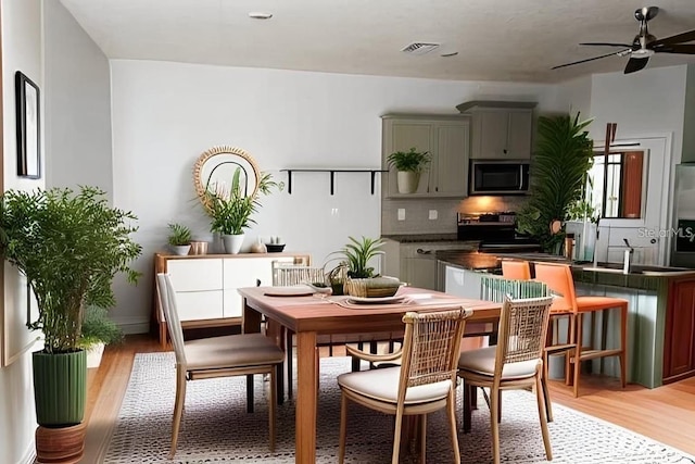 dining room with light hardwood / wood-style flooring and ceiling fan