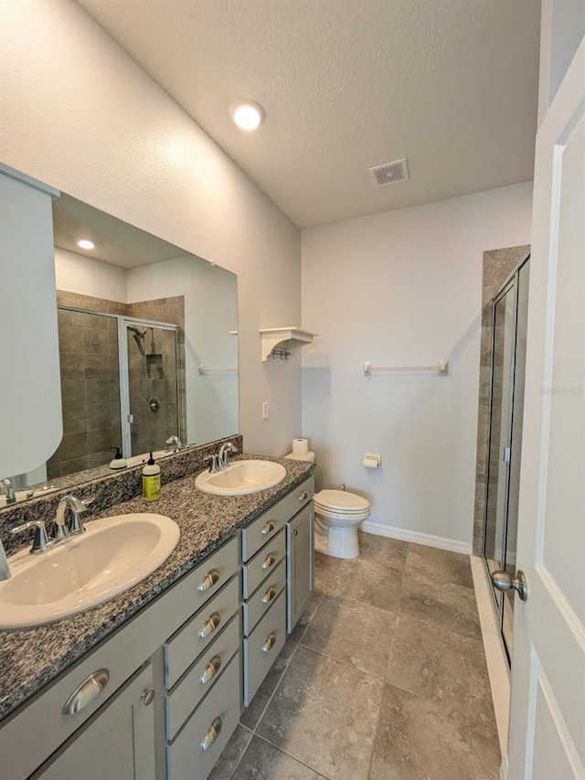 bathroom featuring vanity, toilet, an enclosed shower, and a textured ceiling