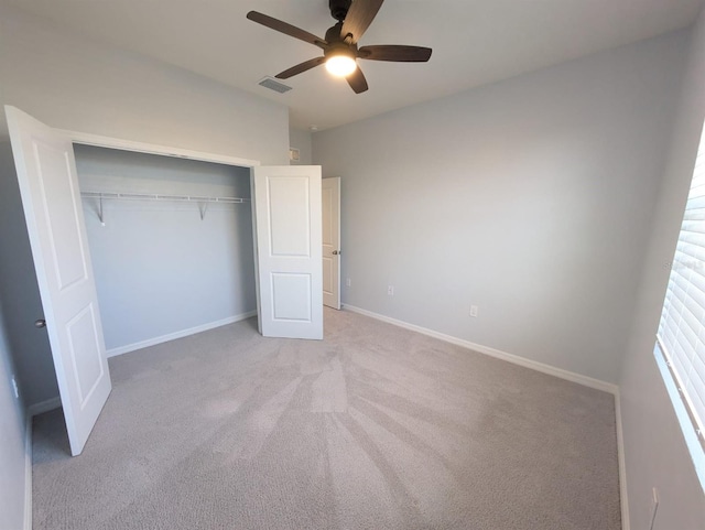 unfurnished bedroom with ceiling fan, light carpet, and a closet