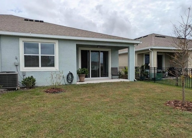 rear view of property featuring a yard and central AC unit