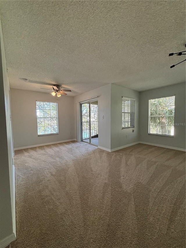 carpeted spare room featuring ceiling fan and a textured ceiling