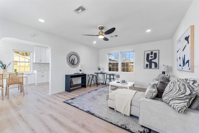 living room with ceiling fan and light hardwood / wood-style flooring