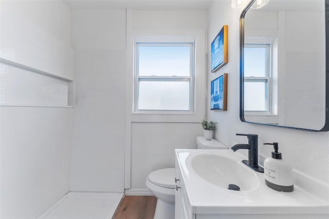 bathroom featuring vanity, wood-type flooring, toilet, and walk in shower