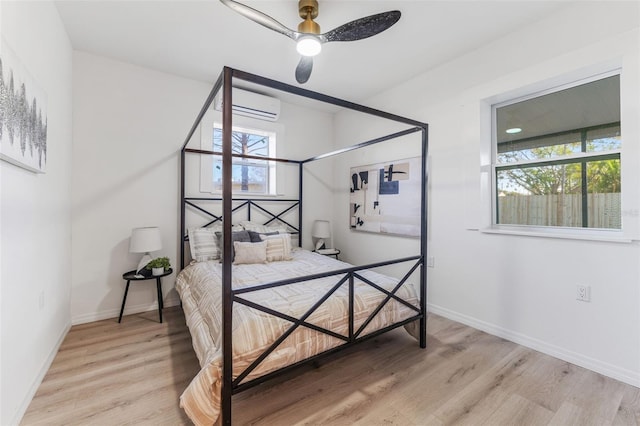 bedroom with an AC wall unit and light hardwood / wood-style floors